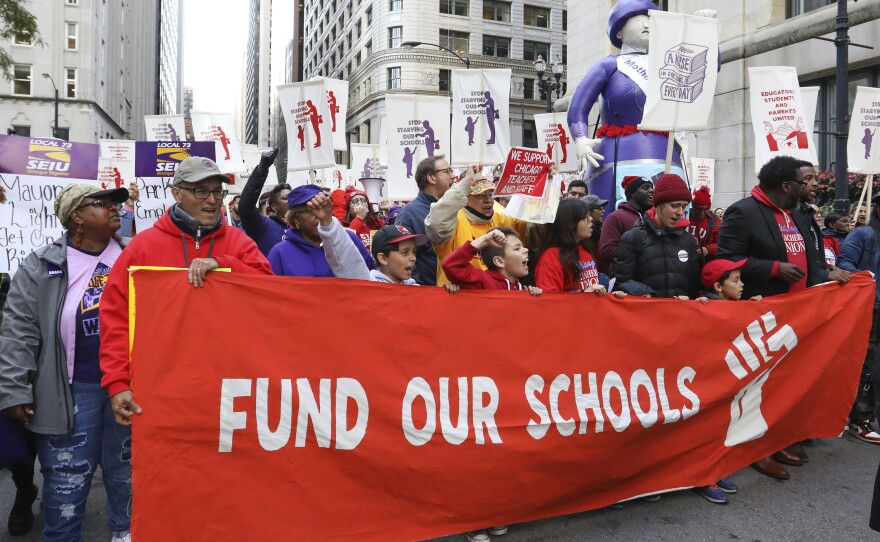 Teachers, staff and their supporters marched through downtown Chicago on Monday to show support for the teachers union.