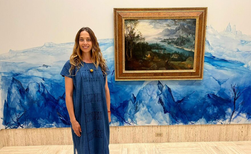 Artist Tatiana Ortiz-Rubio is shown with her mural, part of the "In Blue Time" installation at the Timken Museum. Also shown is the 1557 painting, "Parable of the Sower," by Pieter Brueghel the Elder.