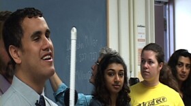 Penn State Ph.D student Cary Supalo (left) demonstrates a voiced computer system that helps visually-impaired chemistry students gain independence in the lab.