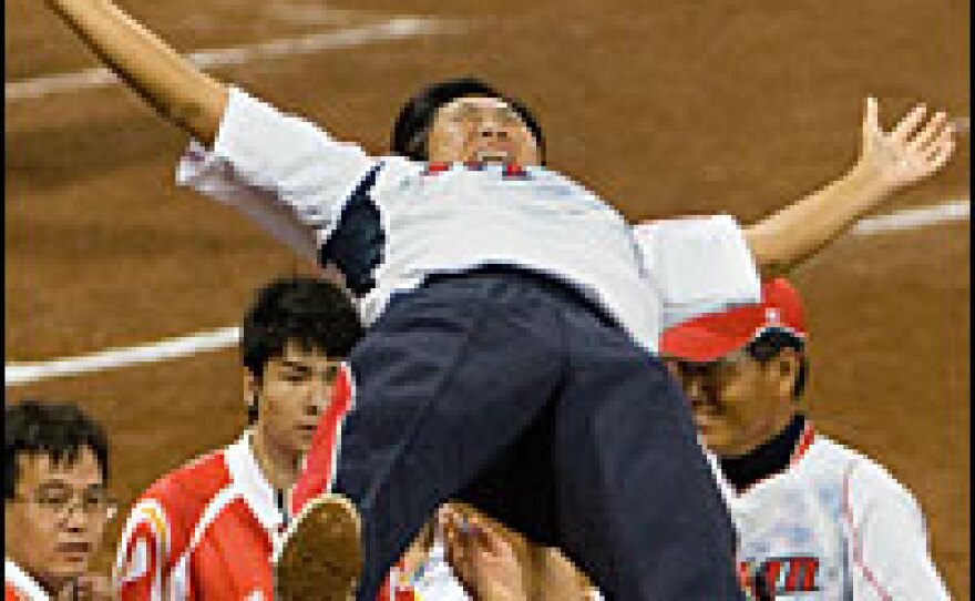 Japanese players lift their coach, Haruka Saito, in celebration after winning the gold medal match against the U.S. on Thursday.