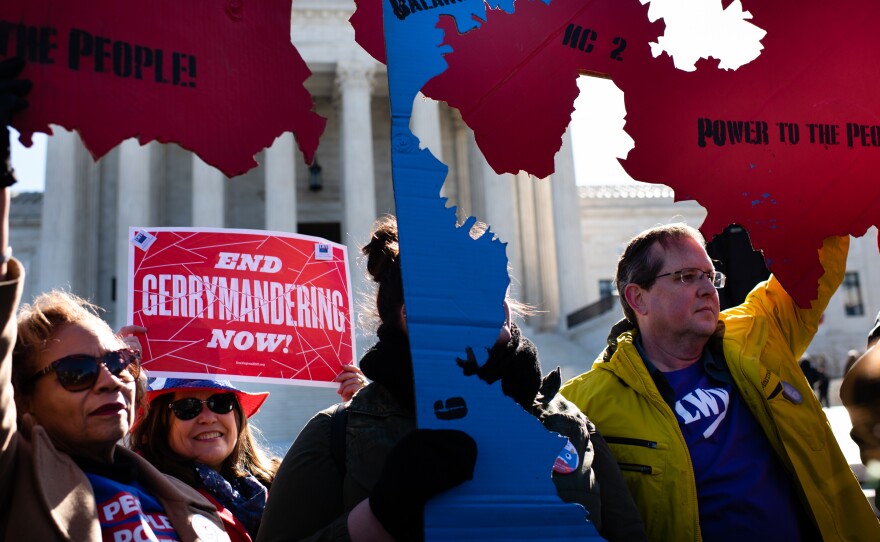 Demonstrators hold signs at a rally about redistricting outside the U.S. Supreme Court in 2019. The Census Bureau said Friday it has "suspended indefinitely" work on citizenship data that a GOP strategist said would be "advantageous to Republicans and Non-Hispanic Whites" during redistricting.