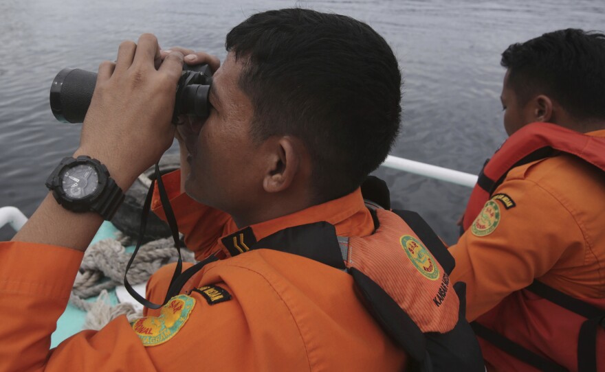 Indonesian rescuers scan the horizon from the deck of a rescue ship as they search for a ferry which sank in Lake Toba, North Sumatra, Indonesia on Monday.