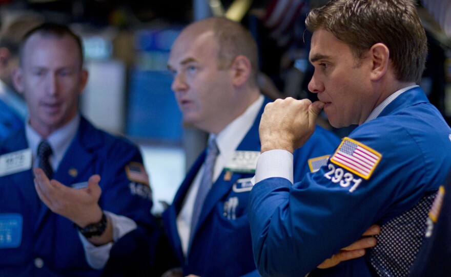 Traders work on the floor of the New York Stock Exchange on Thursday. Stocks sank again as investors continued to fret about the struggling economies in Europe and slow growth in the U.S.