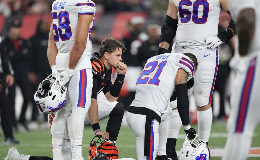 Quarterback Joe Burrow #9 of the Cincinnati Bengals and Jordan Poyer #21 of the Buffalo Bills take a knee after Damar Hamlin of the Bills collapsed following making a tackle during the first quarter at Paycor Stadium on January 02, 2023 in Cincinnati, Ohio.