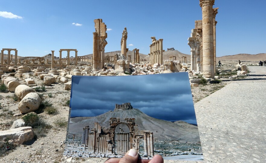 A picture of the Arc du Triomphe (Triumph's Arch) taken on March 14, 2014, in front of the remains of the historic monument as seen on Thursday. The monument was destroyed by Islamic State jihadists in October 2015.