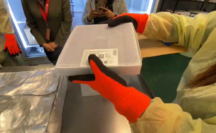 A nurse inspects the first shipment of the COVID-19 vaccine to arrive in San Diego on Dec. 14, 2020.