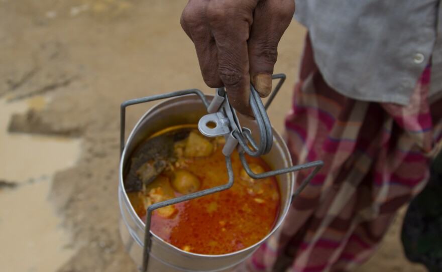 A Rohingya man carries a pot of chicken curry back to his shelter in the Palang Khali refugee camp in Bangladesh. He waited in line all morning to get the food from a soup kitchen run by the Turkish government.