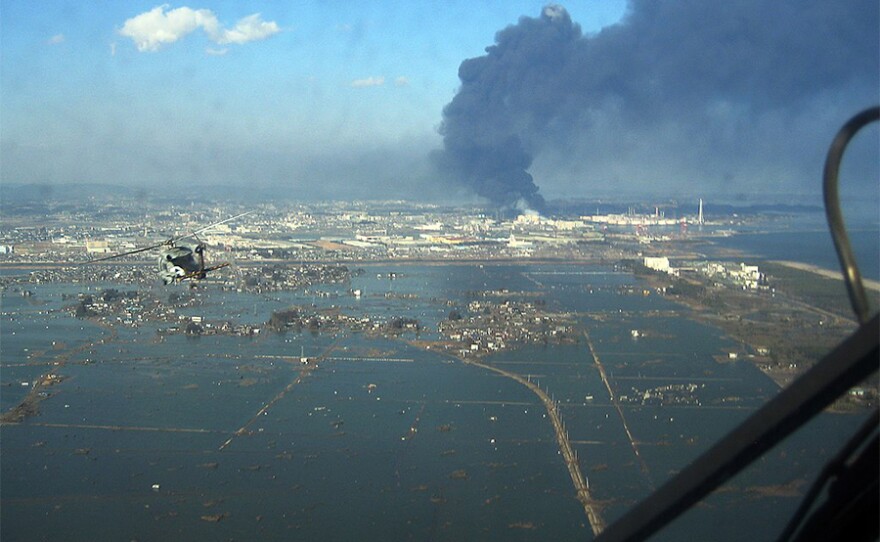 SH-60F helicopter assigned to the Chargers of Helicopter Antisubmarine Squadron (HS) 14 from Naval Air Facility Atsugi flies over the port of Sendai to deliver more than 1,500 pounds of food to survivors of an 9.0 magnitude earthquake and a tsunami (2011 Tōhoku earthquake and tsunami). The citizens of Ebina City, Japan, donated the food, and HS-14 is supporting earthquake and tsunami relief operations in Japan as directed.