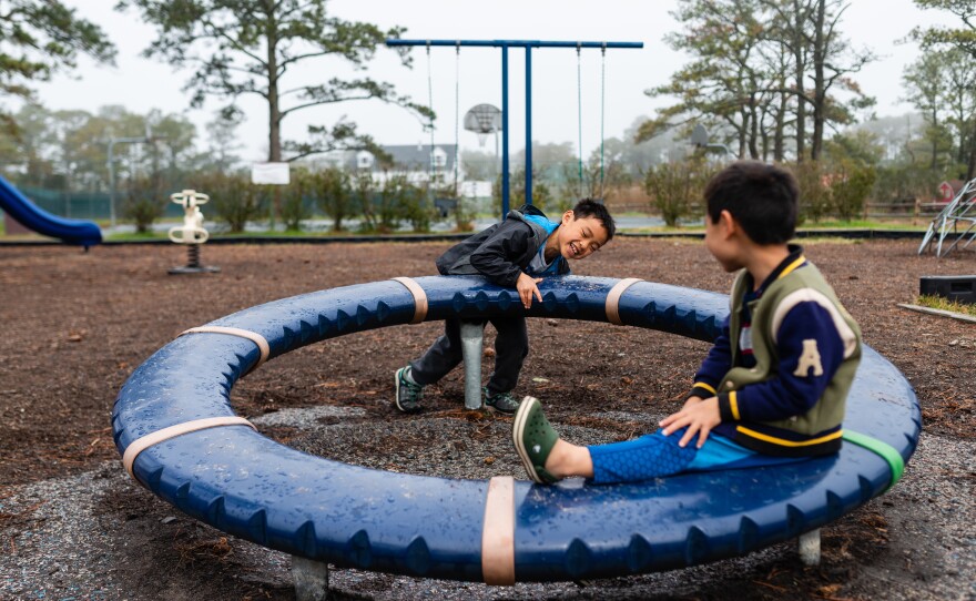 Henry pushes a wheel as Hayle sits on it in a park in Chincoteague, Md., on April 14, 2019.