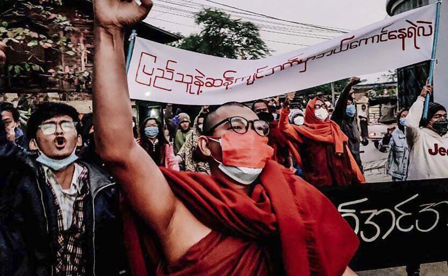 A Buddhist monk raises his clenched fist while marching during an anti-military government protest rally on Tuesday, Feb. 1 in Mandalay, Myanmar. The new U.N. special envoy for Myanmar says violence has intensified since the military took power a year ago and sparked a resistance movement in the country.