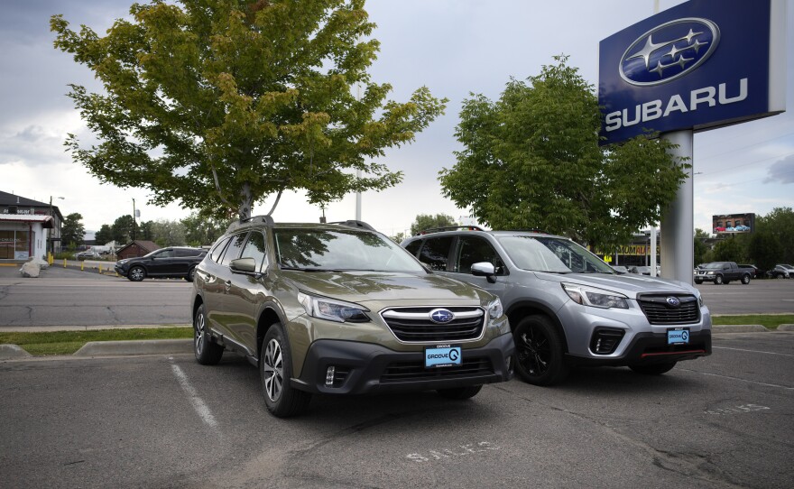 Two unsold 2021 Subaru SUVs sit in an otherwise empty storage lot at a Subaru dealership in Littleton, Colo., on Sept. 12. Ordering a car directly from an automaker can mean long waits, but doing so can be easier than finding a car you want at a dealer.