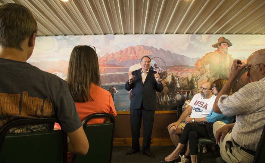 Former Arkansas Gov. Mike Huckabee talks with Iowans at the Pizza Ranch in Jefferson this month.