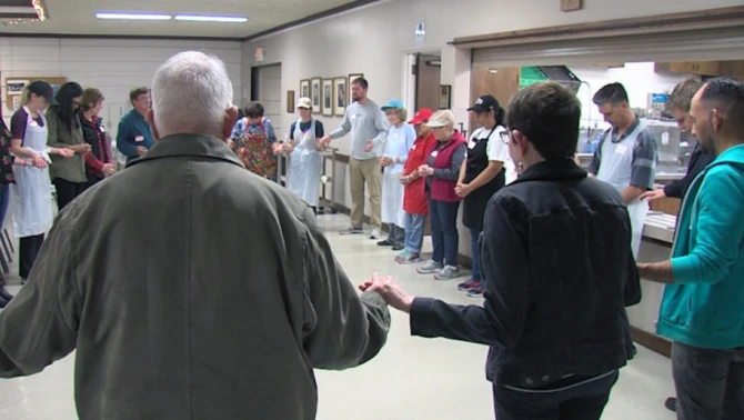 People pray before a free meal served at Saint Brigid Parish in Pacific Beach, January 8, 2018.