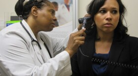 Dr. Wanda Simmons-Clemmons examines Dawn Antonelli at the PromptCare urgent care clinic.