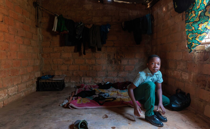 Alumbwe, who's 12 and lives in Zambia, gets ready for school. It's a 2 mile walk from his home. He and his brothers have lived without adult supervision since their parents died of AIDS earlier this year.