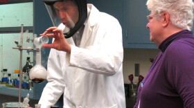 In a chemistry lab at New Mexico Tech, Senior Research Scientist Christa Hockensmith (right) shows David Pogue (left) how to test for elements in bomb debris.