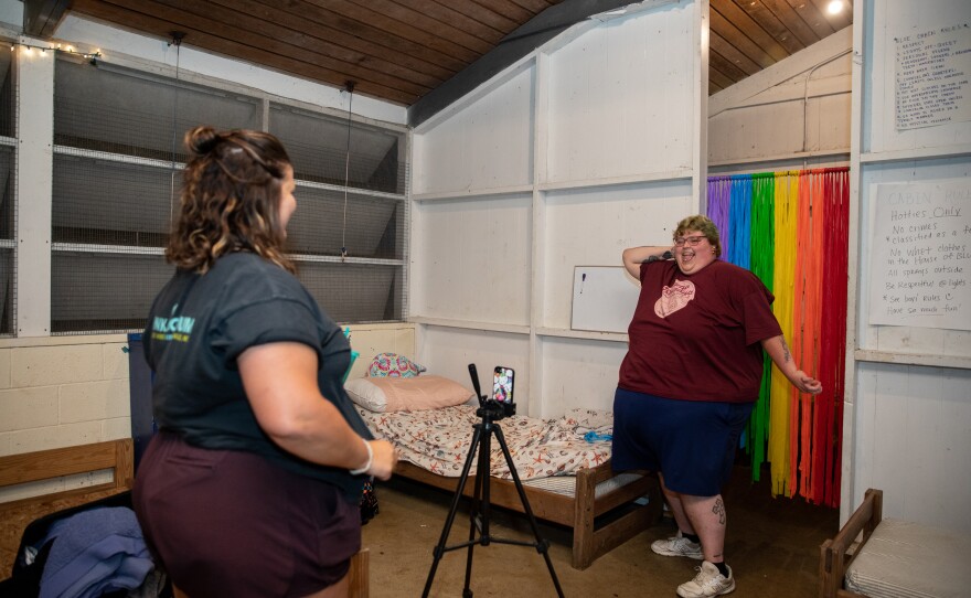 Molly Brubaker watches Jill Baugess record a TikTok of herself dancing in a Camp Roundup T-shirt after dinner on the first night of camp.
