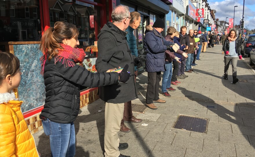 People pass books down a chain to help the bookstore October Books move to a new location on Sunday in Southampton, England.