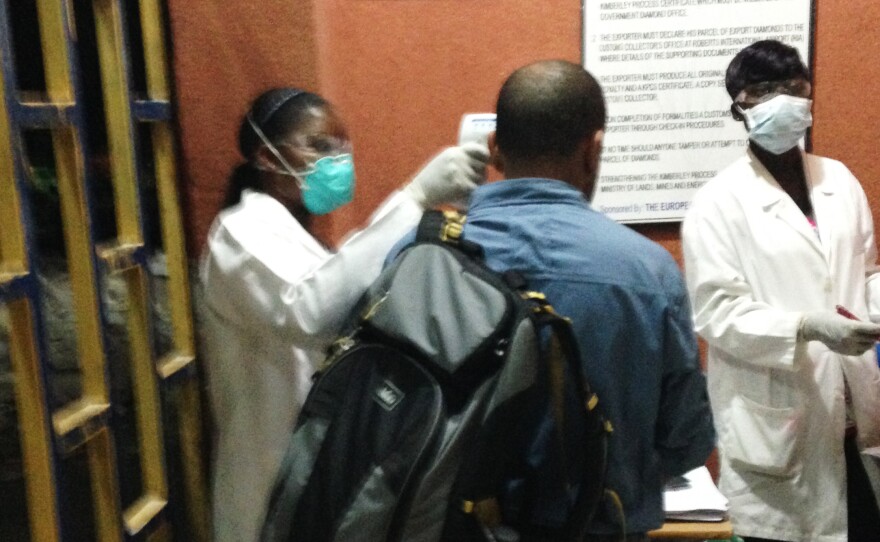 NPR producer Rolando Arrieta approaches the Ebola screening station at the airport in Monrovia, Liberia.