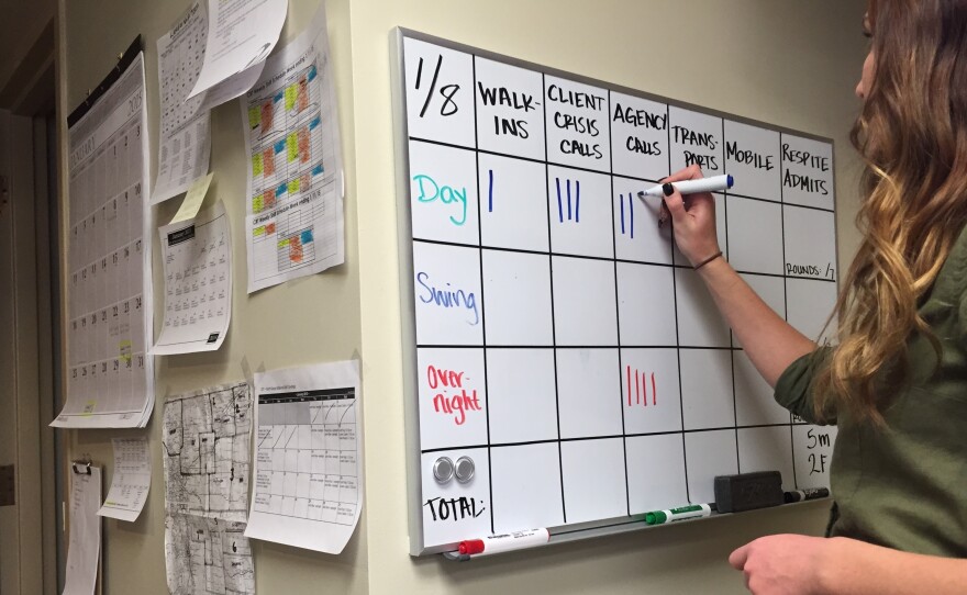 Mental health therapist Shaundra Drysdale updates daily use numbers inside a crisis support services center in Greeley, Colo.