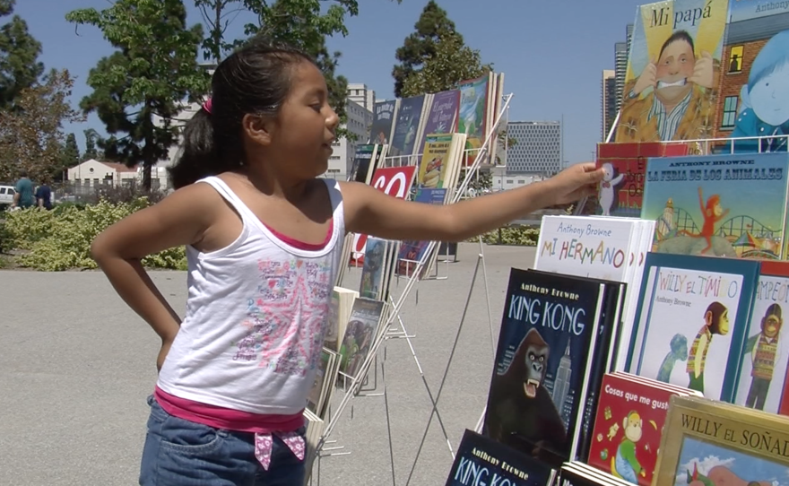 Kaily Gonzalez picks up a copy of "El Libro del Osito," Aug. 29, 2015. 