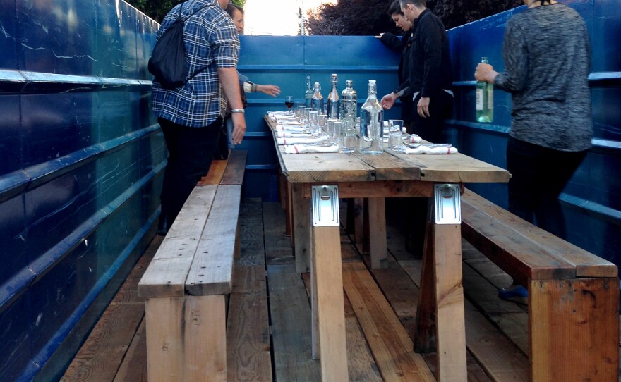 This San Francisco dumpster was decorated with glass tea lights, long wooden benches and bar towel napkins for the Salvage Supperclub dinner.