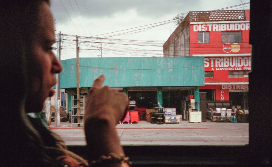 Liset points out the window of a bus while on the way to Guatemala City.