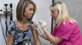 In this Tuesday, Dec. 18, 2007 file photo, Lauren Fant, left, winces as she has her third and final application of the Human Papillomavirus (HPV) vaccine administered by nurse Stephanie Pearson at a doctor's office in Marietta, Ga. 