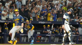 Milwaukee Brewers' Garrett Mitchell, left, celebrates past Tampa Bay Rays catcher Nick Fortes after scoring during the fifth inning of Game 3 of baseball's World Series, Monday, Oct. 26, 2026, in St. Petersburg, Fla., between the Milwaukee Brewers and the Tampa Bay Rays.