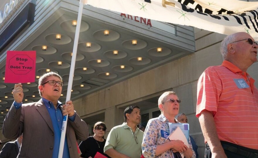 Gordon Martinez (left), leader of the group Faith in Texas and payday loan borrower, marches before a Consumer Financial Protection Bureau field hearing in Kansas City on June 2.