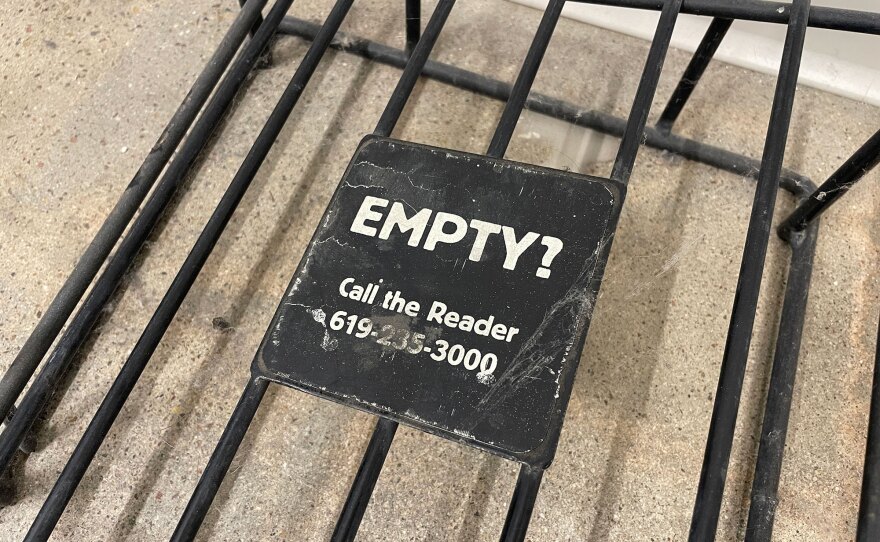A empty rack previously held issues of the San Diego Reader, shown on Feb. 18, 2025. A sign says "Empty? Call the Reader." with a phone number.