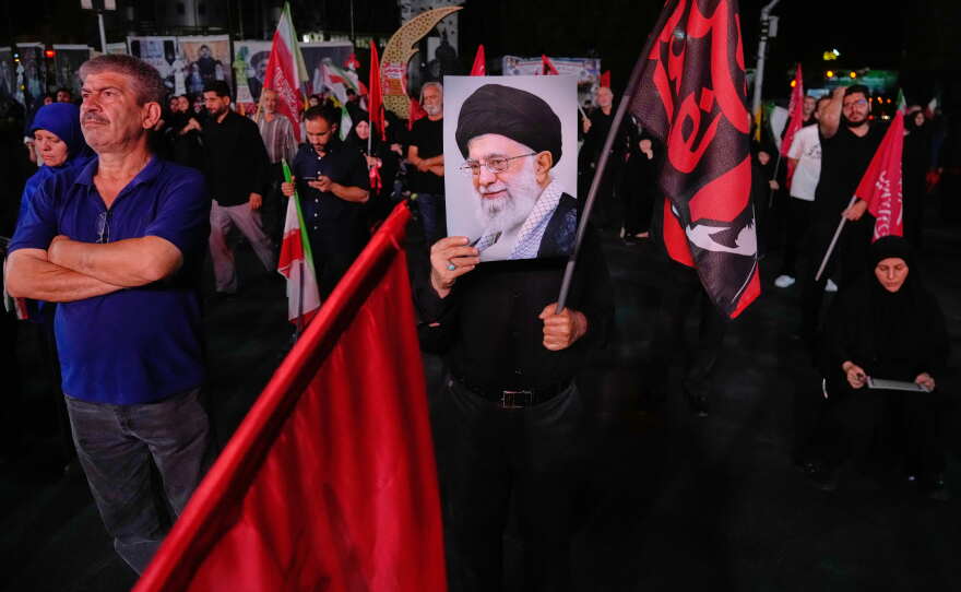A man holds a poster of the late Iranian Supreme Leader Ayatollah Ali Khamenei in a gathering commemorating him at a square in Tehran, Saturday, July 11, 2026.