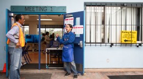 Poll worker Nolan Richardson, left, speaks with Site Supervisor Emmanuel Millan at the Martin Luther King Jr. Recreation Center in San Diego on Nov. 8, 2022.