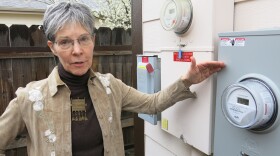 K.K. DuVivier stands by a smart meter that sends electricity back to her utility, Xcel Energy. The Denver home gets credits from Xcel for power that's added back to the grid.