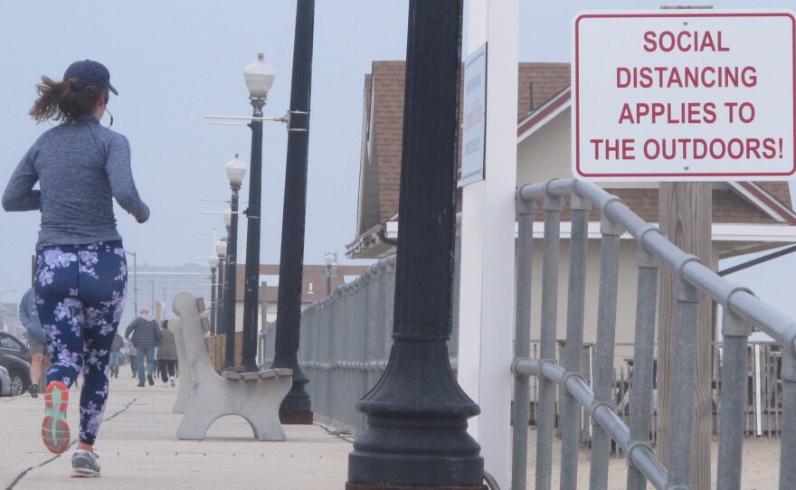 A sign on the Bradley Beach, N.J., oceanfront urges people to practice social distancing even in the outdoors during the coronavirus outbreak. On Saturday, New Jersey Gov. Phil Murphy signed an executive order directing all residents to stay at home.