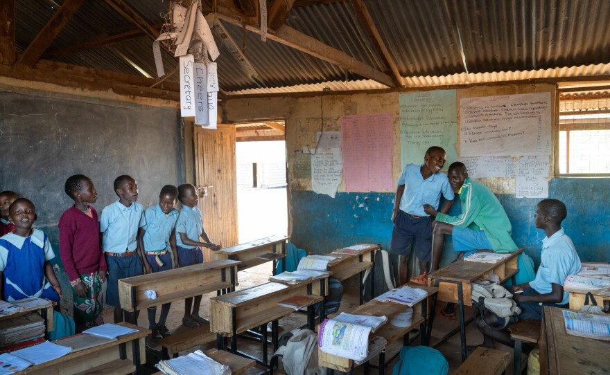 Saidimu, Loshaki and Paris look on as their much younger third-grade classmates sing a song.
