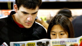 Tom and Vicki Hendrix of Marblehead, Mass., examine a Best Buy flier. Some analysts say the intense focus on "door busters" — low-priced items meant to entice shoppers — and pricing has resulted in disappointing ads this season.