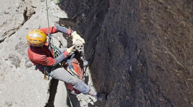 Climber Pete Athans removes a skull from an eroded cliffside cave in Nepal's Mustang region.