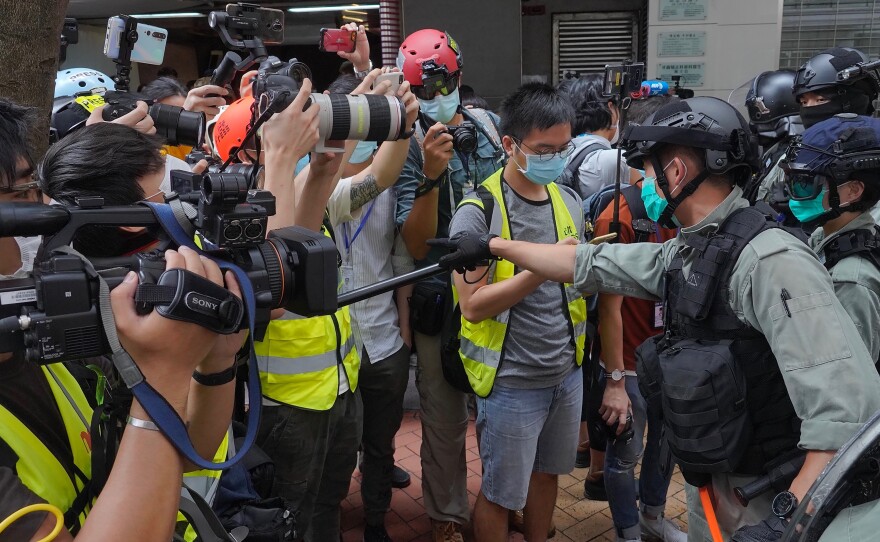 Riot police clear away media gathered in Hong Kong last week ahead of debate on a bill that would criminalize abuse of the Chinese national anthem. China has accused the U.S. of "double standards" in its support for anti-China protests in Hong Kong and its criticism of Beijing's human rights record.
