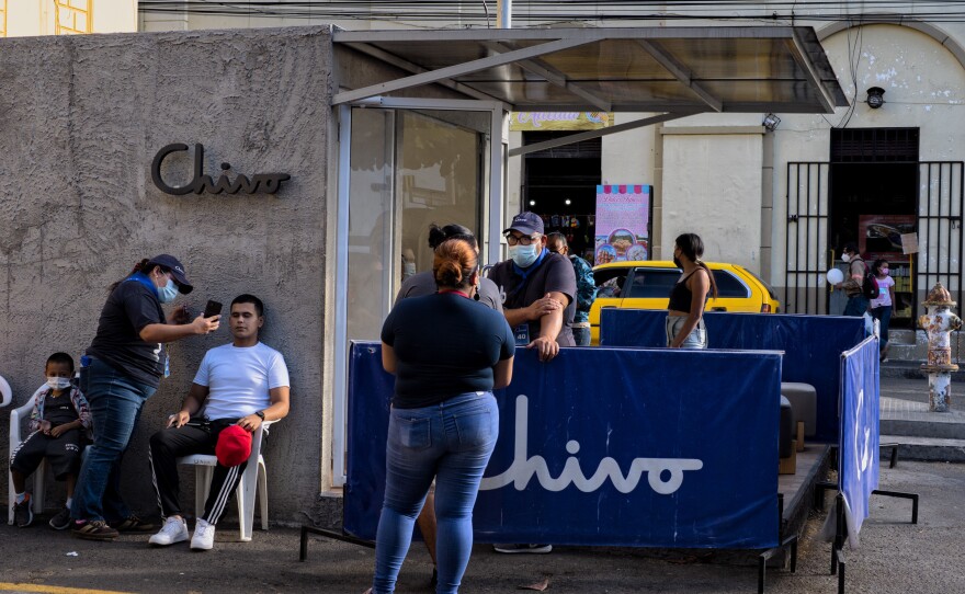 People get help on issues or setting up their digital wallet at a Chivo Wallet ATM post. The Salvadoran government offered residents $30 worth of bitcoin to use the new digital wallet, though some Salvadorans say they took the money out rather than use the bitcoins.