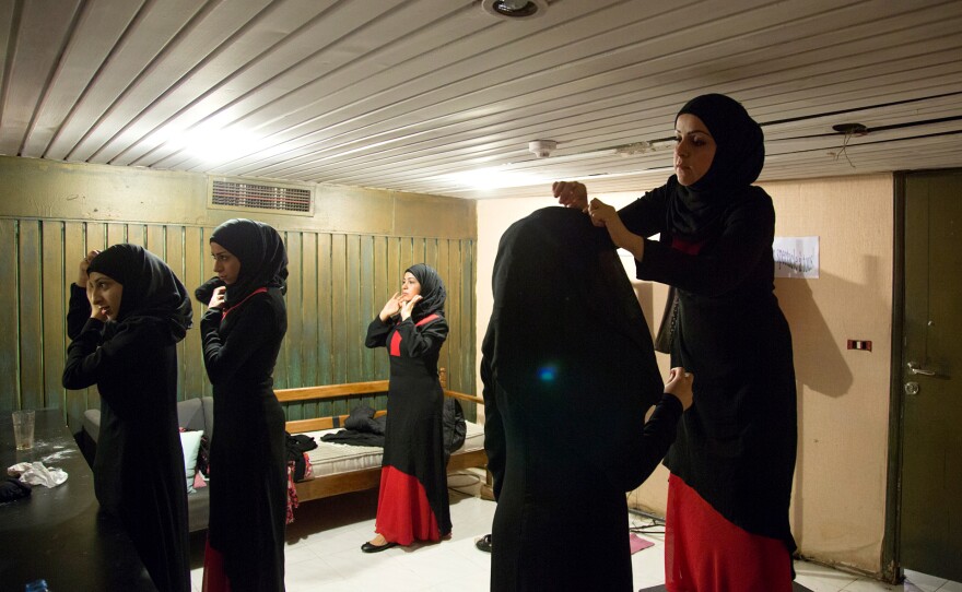 Syrian refugee women in Beirut, Lebanon, fix their veils in a dressing room before a rehearsal of an Arabic version of Antigone. The women are part of production that's been adapted to incorporate their experiences in an effort to help them heal.