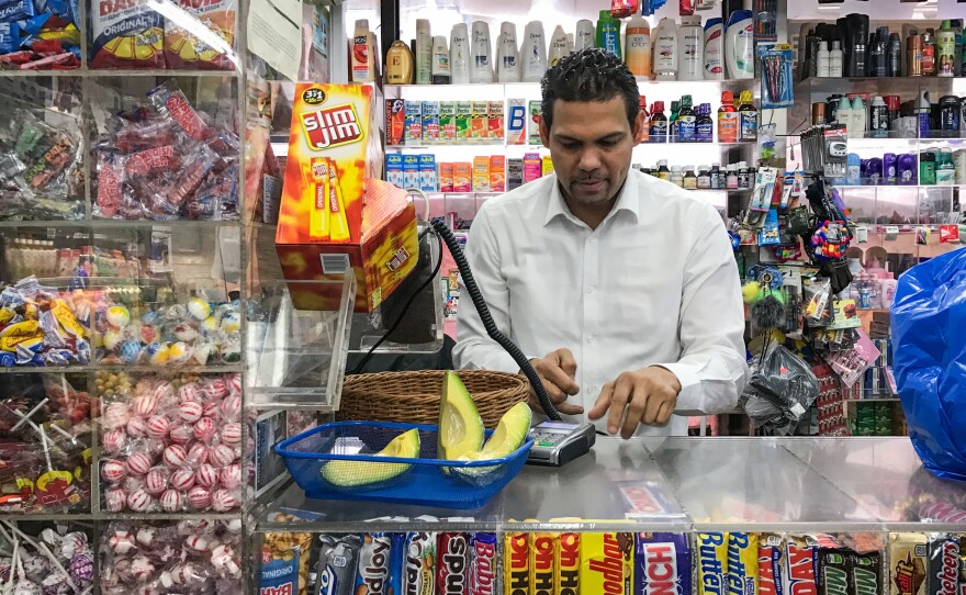 Merquis Garcia works A & M Supermarket's counter, where customers can pick up slices of fresh avocado and candied pineapple.