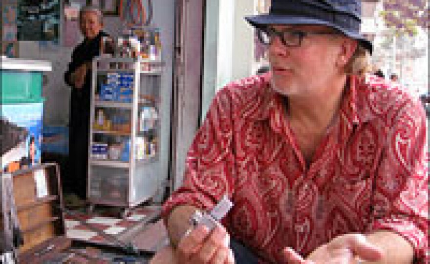 American artist Bradford Edwards, who has lived in Vietnam for 15 years, talks with a vendor selling Zippo lighters in Ho Chi Minh City. Edwards estimates that he has examined more than 100,000 Zippos.