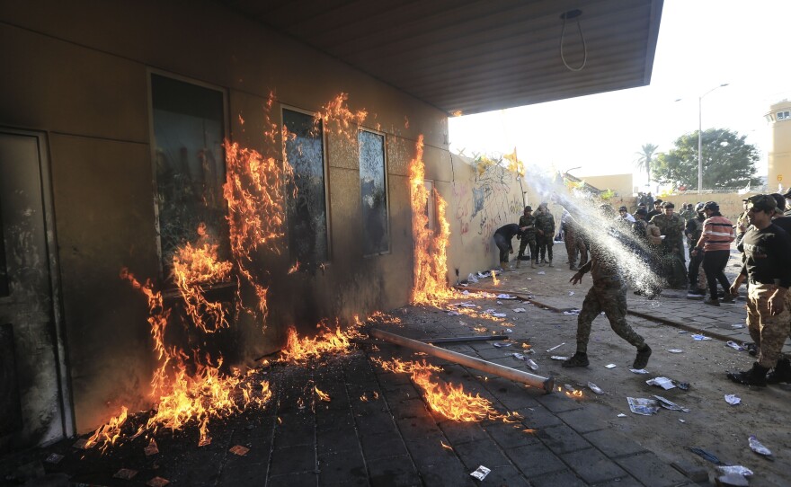 Outraged Iraqi protesters, angered by U.S. strikes on armed battalions belonging to an Iranian-backed militia, attack the U.S. Embassy in Baghdad on Tuesday.