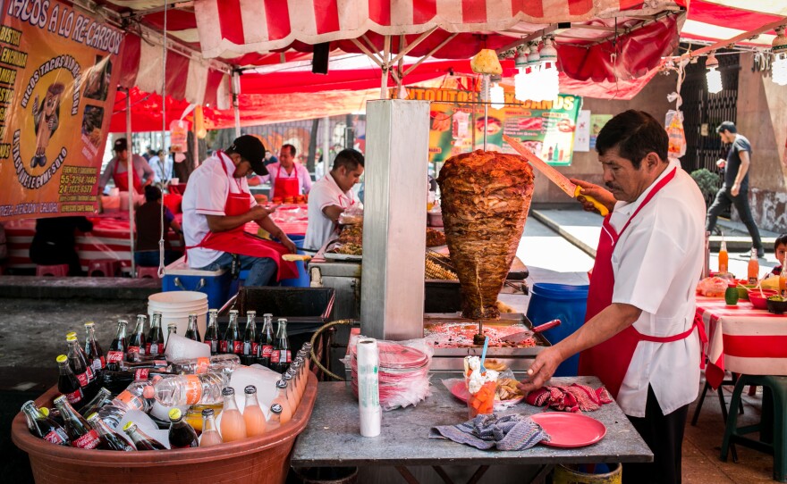 Rich, fatty street food is available all over Mexico. This vendor prepares tacos al pastor, with the meat cooked on a spit, outside a metro station in Mexico City.