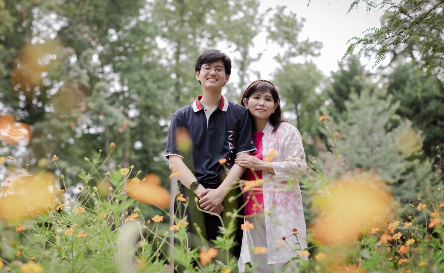 An Nguyen stands with his mother, Tu HoNguyen, for a portrait at George Mason University, where he completed his undergraduate degree and is currently pursuing his master's.