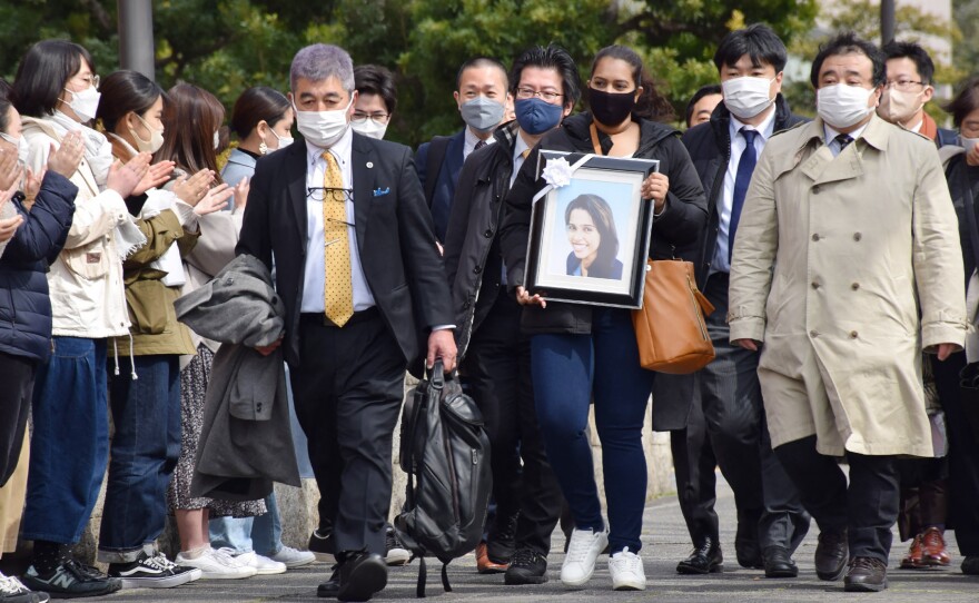 Poorima Sandamali carries a picture of her sister, Wishma Sandamali, a Sri Lankan woman who died while in Japanese immigration detention in 2021, as she walks to the Nagoya district court to file a lawsuit against the government of Japan on March 4.