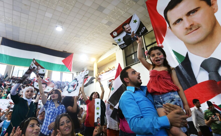 Syrians in the capital Damascus hold posters with portraits of President Bashar Assad ahead of the country's June election. He was overwhelmingly elected in a vote that Western countries called illegitimate.