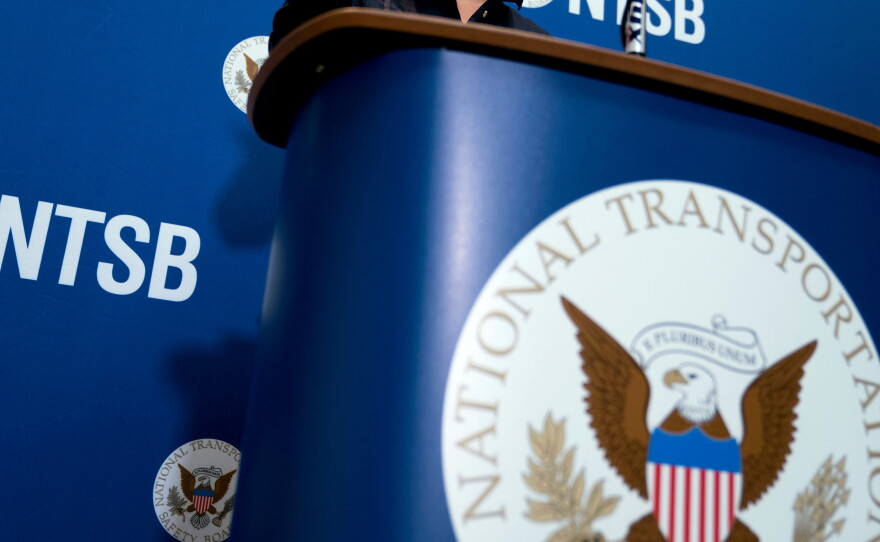 FILE - The National Transportation Safety Board logo and signage are seen at a news conference at NTSB headquarters in Washington, Dec. 18, 2017.