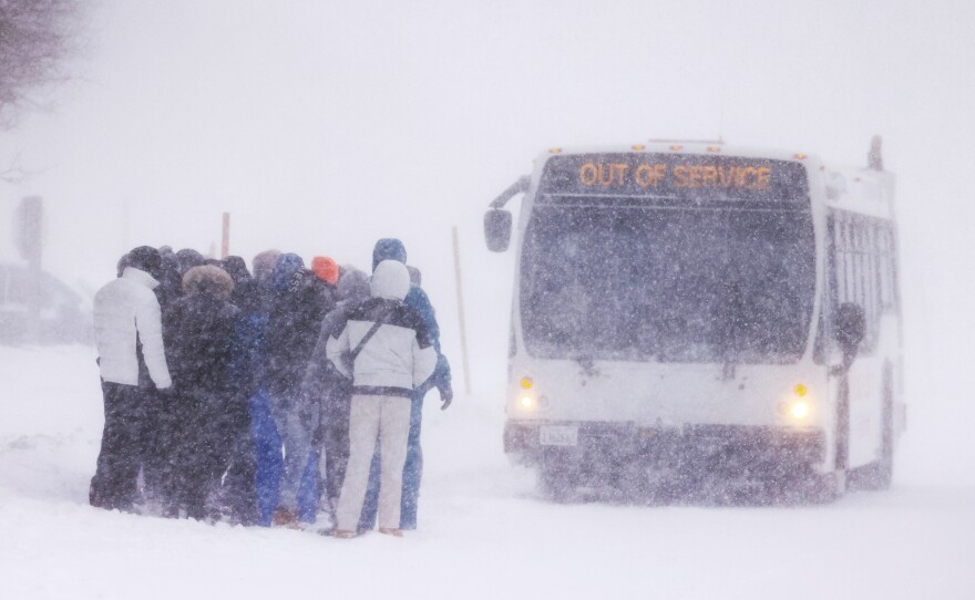 A group waits at a bus stop for an 'out of service' bus pull up as a blizzard hits Mammoth Lakes in the Eastern Sierra Nevadas of California, on Saturday.